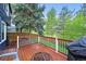 Outdoor back deck with wood flooring, and a view of the grassy back yard at 7927 Elmwood St, Littleton, CO 80125
