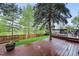 Wet, wooden deck is surrounded by green grass and trees, providing a serene and private outdoor space at 7927 Elmwood St, Littleton, CO 80125