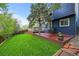Backyard features a well-manicured lawn, wooden deck, and a backdrop of lush greenery creating a serene outdoor space at 7927 Elmwood St, Littleton, CO 80125