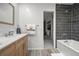 Modern bathroom featuring a vanity, toilet, shower over tub, and a glimpse into the organized walk-in closet at 7927 Elmwood St, Littleton, CO 80125