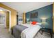 Comfortable bedroom with closet, neutral carpet, and a combination of yellow and teal painted walls at 7927 Elmwood St, Littleton, CO 80125