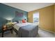 Bedroom with neutral carpet, two-tone teal and gold walls, and a double bed under a window at 7927 Elmwood St, Littleton, CO 80125