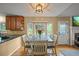 Bright dining room with wood floors, a bay window, a rustic table, and a glass door at 7927 Elmwood St, Littleton, CO 80125