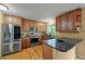 Modern kitchen features stainless steel appliances, granite countertops, and wood cabinets at 7927 Elmwood St, Littleton, CO 80125