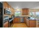 Modern kitchen features stainless steel appliances, granite countertops, and wood cabinets at 7927 Elmwood St, Littleton, CO 80125