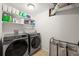 Well-lit laundry room with modern front-loading washer and dryer at 7927 Elmwood St, Littleton, CO 80125