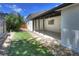 Landscaped backyard features a covered patio, artificial turf, and rock garden at 3469 Benton St, Wheat Ridge, CO 80212