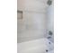 Bathroom tub featuring modern tiles, sleek fixtures, and a built-in shelf for convenience and style at 3469 Benton St, Wheat Ridge, CO 80212