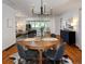 Bright dining room area with a wooden table and modern lighting fixture with hardwood floors and open living area at 3469 Benton St, Wheat Ridge, CO 80212