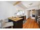 Kitchen featuring a black island with butcher block top, and white cabinets with marble backsplash at 3469 Benton St, Wheat Ridge, CO 80212