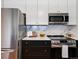 Modern kitchen features stainless steel appliances, white cabinets, and elegant marble backsplash at 3469 Benton St, Wheat Ridge, CO 80212