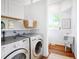 Bright laundry room with white cabinets, utility sink, and modern washer and dryer at 3469 Benton St, Wheat Ridge, CO 80212
