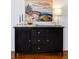 Living Room credenza with a dark finish, paired with artwork and decor for a warm and inviting feel at 3469 Benton St, Wheat Ridge, CO 80212