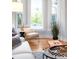 Bright bay window accented with an oversized plant, modern chair, and hardwood floors at 3425 W 34Th Ave, Denver, CO 80211