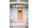 Charming front porch with peach-colored door and wreath, accented with a porch swing and potted flowers at 3425 W 34Th Ave, Denver, CO 80211