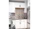 Bright kitchen featuring white cabinetry, mosaic backsplash, stainless steel appliances and dark countertop at 3425 W 34Th Ave, Denver, CO 80211