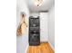 Laundry room features stacked washer and dryer, storage cabinet, and wood floors at 3425 W 34Th Ave, Denver, CO 80211