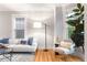 Living room featuring hardwood floors, a cozy couch with decor pillows, and a modern floor lamp at 3425 W 34Th Ave, Denver, CO 80211