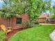 Secluded backyard oasis with brick walls, a green lawn, and lush landscaping at 1247 Dexter St, Denver, CO 80220