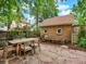 Charming backyard patio with stone pavers, wooden dining set, string lights, and a brick garage at 1247 Dexter St, Denver, CO 80220