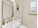 Bright bathroom with a pedestal sink, window, and bathtub with shower at 1247 Dexter St, Denver, CO 80220