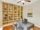 Spacious bedroom featuring built-in shelving, modern desk, ceiling fan, and hardwood floors at 1247 Dexter St, Denver, CO 80220