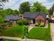 Charming brick home featuring a lush lawn, mature trees, and a detached garage, complemented by a neatly manicured front yard at 1247 Dexter St, Denver, CO 80220