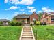 Charming brick home featuring a cozy front porch, well-maintained lawn, and inviting curb appeal on a bright, sunny day at 1247 Dexter St, Denver, CO 80220
