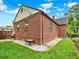 Brick exterior with a small yard featuring fresh green grass and mature landscaping at 1247 Dexter St, Denver, CO 80220