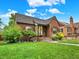 Charming brick home featuring a cozy front porch, well-maintained lawn, and inviting curb appeal on a bright, sunny day at 1247 Dexter St, Denver, CO 80220