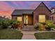 Charming brick home featuring a cozy front porch, well-maintained lawn, and inviting curb appeal under a colorful evening sky at 1247 Dexter St, Denver, CO 80220