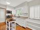 Well-lit kitchen with white cabinetry, stainless steel appliances, and hardwood floors at 1247 Dexter St, Denver, CO 80220