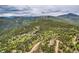 Scenic aerial view showcasing the natural beauty of the wooded land with rolling hills and snow-capped mountain backdrop at 266 Lodgepole Dr, Evergreen, CO 80439