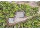 Aerial view of a secluded home and detached garage, nestled in a dense, leafy forest at 266 Lodgepole Dr, Evergreen, CO 80439