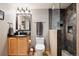 Comfortable bathroom featuring wood vanity, toilet, walk-in shower with black decorative tiles, and chrome fixtures at 266 Lodgepole Dr, Evergreen, CO 80439