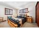 Charming bedroom with rustic wood bed frame, matching nightstands, and windows with dark wood trim at 266 Lodgepole Dr, Evergreen, CO 80439