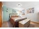 Cozy bedroom with a metal bed frame, and wooden storage bench, offering a blend of comfort and functionality at 266 Lodgepole Dr, Evergreen, CO 80439