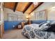 Unique bedroom featuring a blue accent wall, a vaulted wood ceiling, and natural light from the windows at 266 Lodgepole Dr, Evergreen, CO 80439