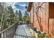 Relaxing outdoor deck with dining area and scenic views of the surrounding trees at 266 Lodgepole Dr, Evergreen, CO 80439