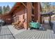 Outdoor deck featuring wooded furniture, table, and mountain views, perfect for outdoor relaxation and enjoyment at 266 Lodgepole Dr, Evergreen, CO 80439