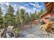 Spacious deck featuring a comfortable chair overlooking the serene landscape and forest at 266 Lodgepole Dr, Evergreen, CO 80439