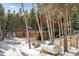 Mountain home with a deck, stone foundation, hot tub, and detached garage nestled in a grove of aspen trees at 266 Lodgepole Dr, Evergreen, CO 80439