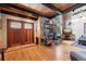 Open-concept living room with a stone fireplace, wood floors, and a charming entryway with stained glass accents at 266 Lodgepole Dr, Evergreen, CO 80439