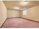 Carpeted basement provides flexible living space with natural light from a window at 8610 E Eastman Ave, Denver, CO 80231