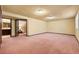 Spacious carpeted basement area with a doorway leading to an additional room with a sink and vanity at 8610 E Eastman Ave, Denver, CO 80231