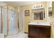 Bathroom features a glass shower stall, dark wooden vanity, and a white countertop and white tile floors at 8610 E Eastman Ave, Denver, CO 80231