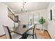 Stylish dining room with hardwood floors, a dark wood table, modern lighting, and stairway access at 8610 E Eastman Ave, Denver, CO 80231