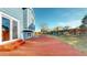 Wide wooden deck with red paint with grass and fencing extending to the property's border at 1265 Iris Ct, Highlands Ranch, CO 80126