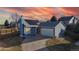 Attractive blue home with a well-manicured lawn, paved driveway and solar panels on roof at 1265 Iris Ct, Highlands Ranch, CO 80126