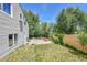 Fenced backyard with a patio, green grass, and a landscaped garden area at 3145 S Bryant St, Englewood, CO 80110